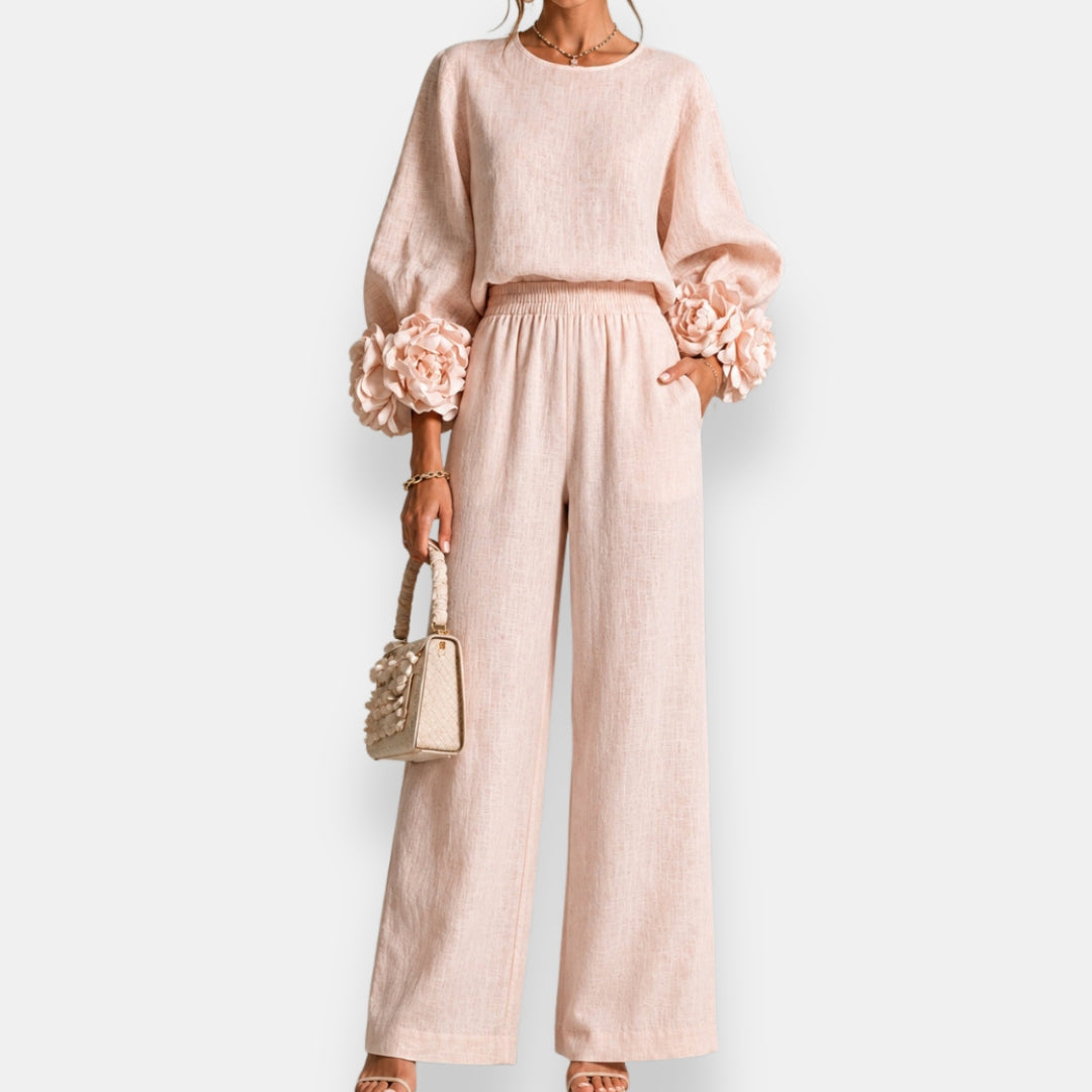 Side profile of a model wearing graceful wide-leg trousers in a soft pink, illustrating natural movement.