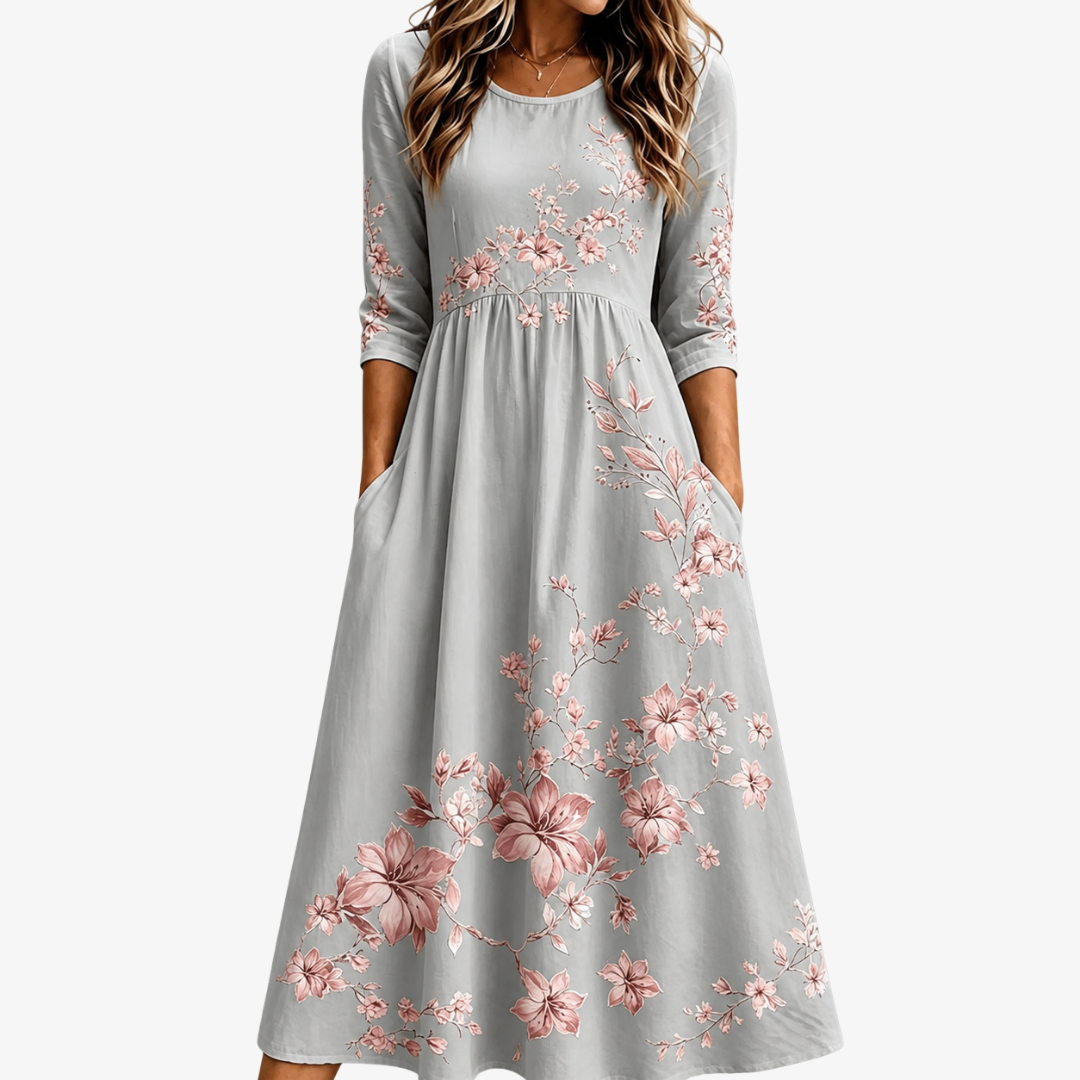 Front view of the Anouk floral print midi dress in light grey, showcasing its elegant pink blossom hem and flowing silhouette.
