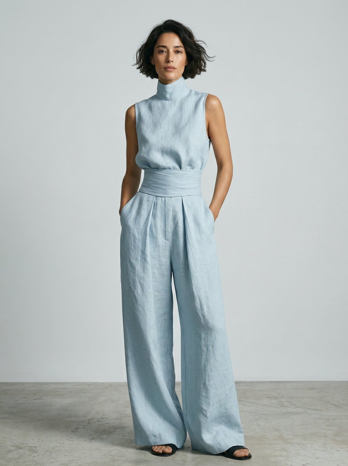 Lifestyle shot of women's wide-leg trousers worn casually with flat sandals for a relaxed summer look.