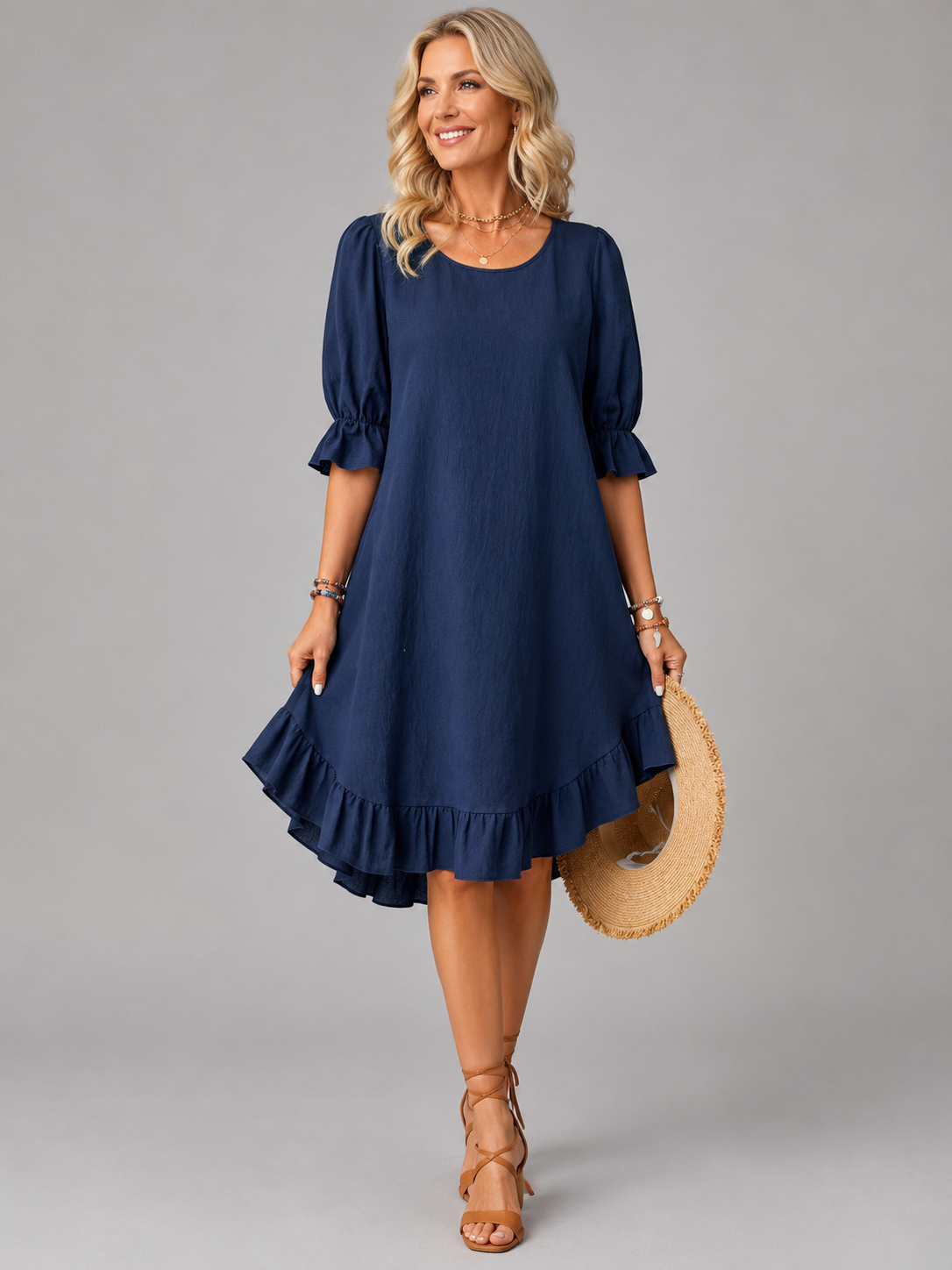 Full-length view of a woman wearing the Nora flowing ruffle midi dress in blue, standing outdoors.