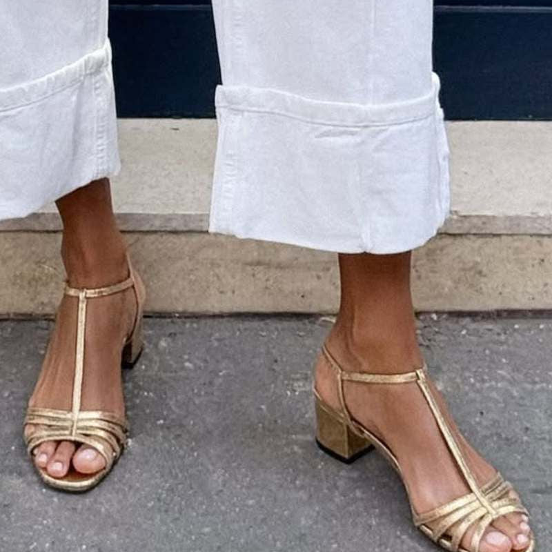 Close-up of the golden detail and strap design of the Allegra vintage sandals.