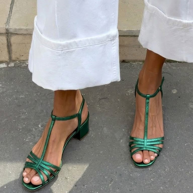 Allegra vintage sandals in gold, placed next to a beach-inspired accessory.