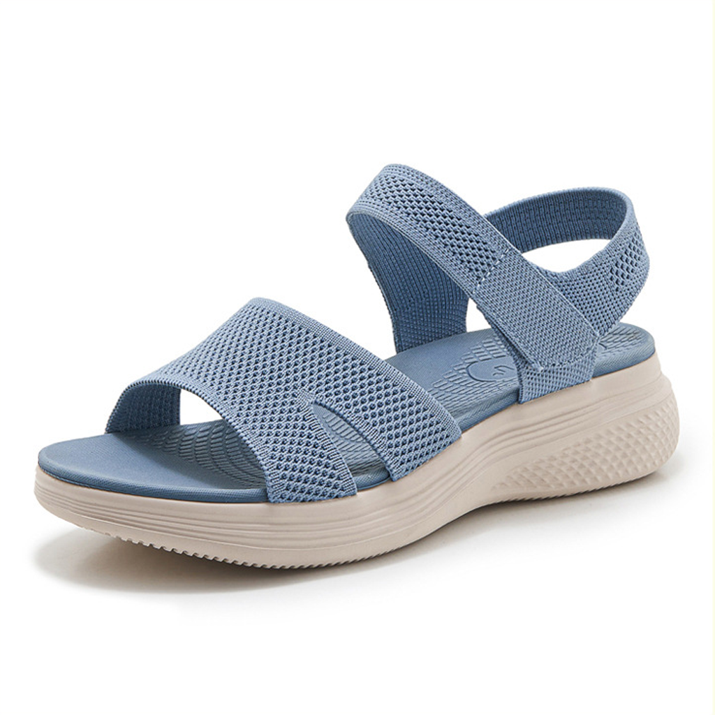 A model wearing the beige supportive walking sandals while strolling on a paved pathway, viewed from the front.