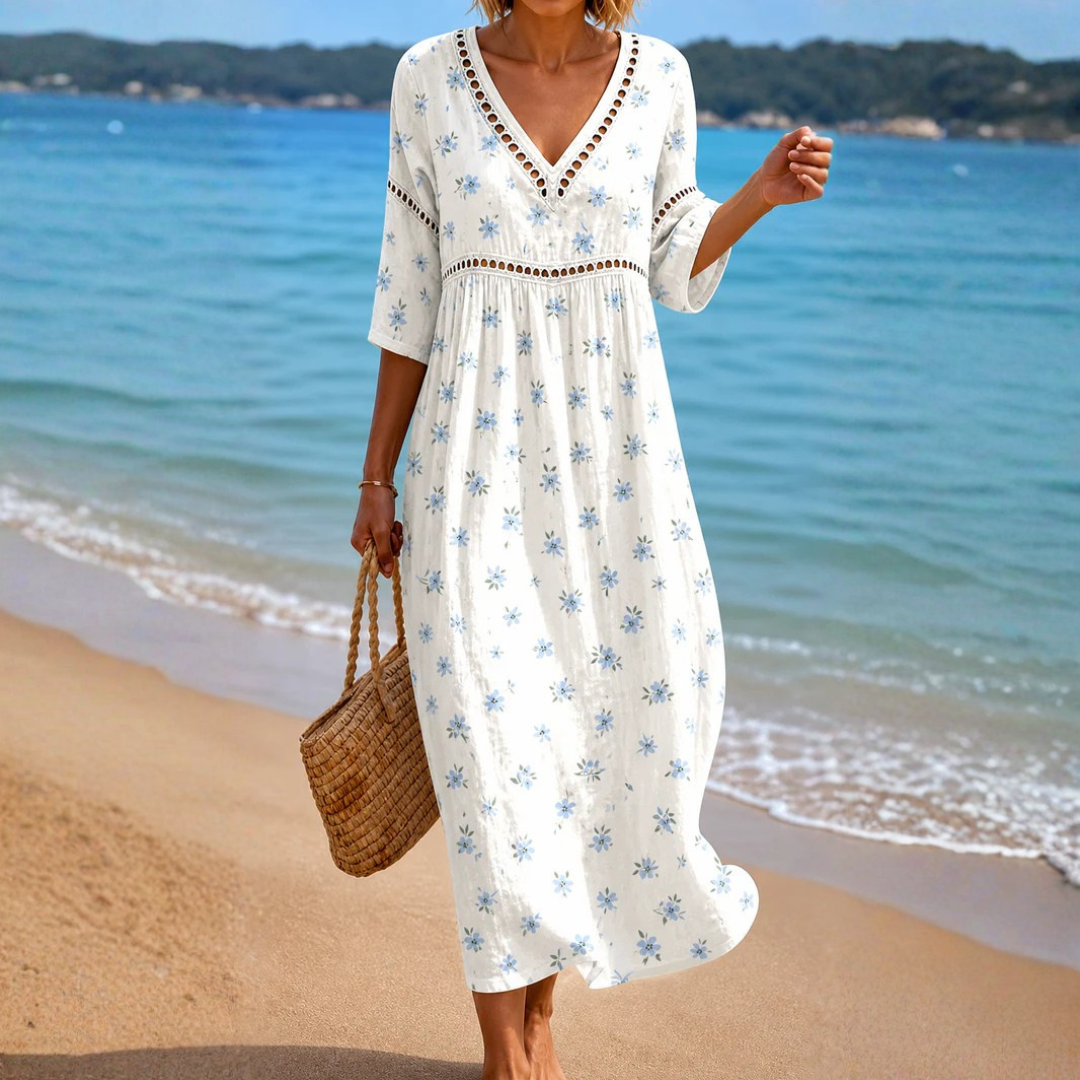 A model wearing the Camille flowing summer midi dress with small blue floral print, showcasing its relaxed fit and elegant drape.