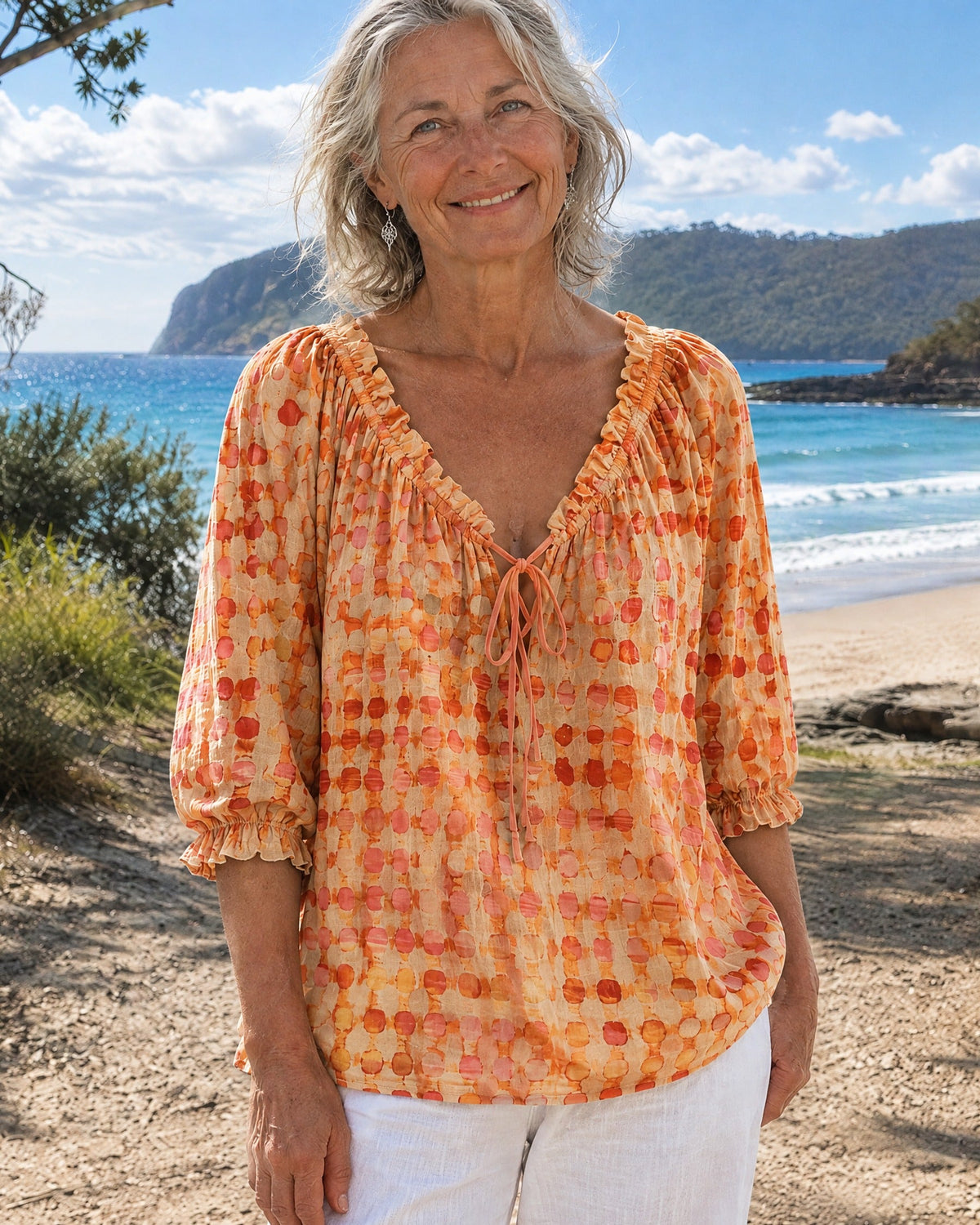 Orange polka dot blouse, showcasing the versatility of the tie-neck worn open for a carefree style.