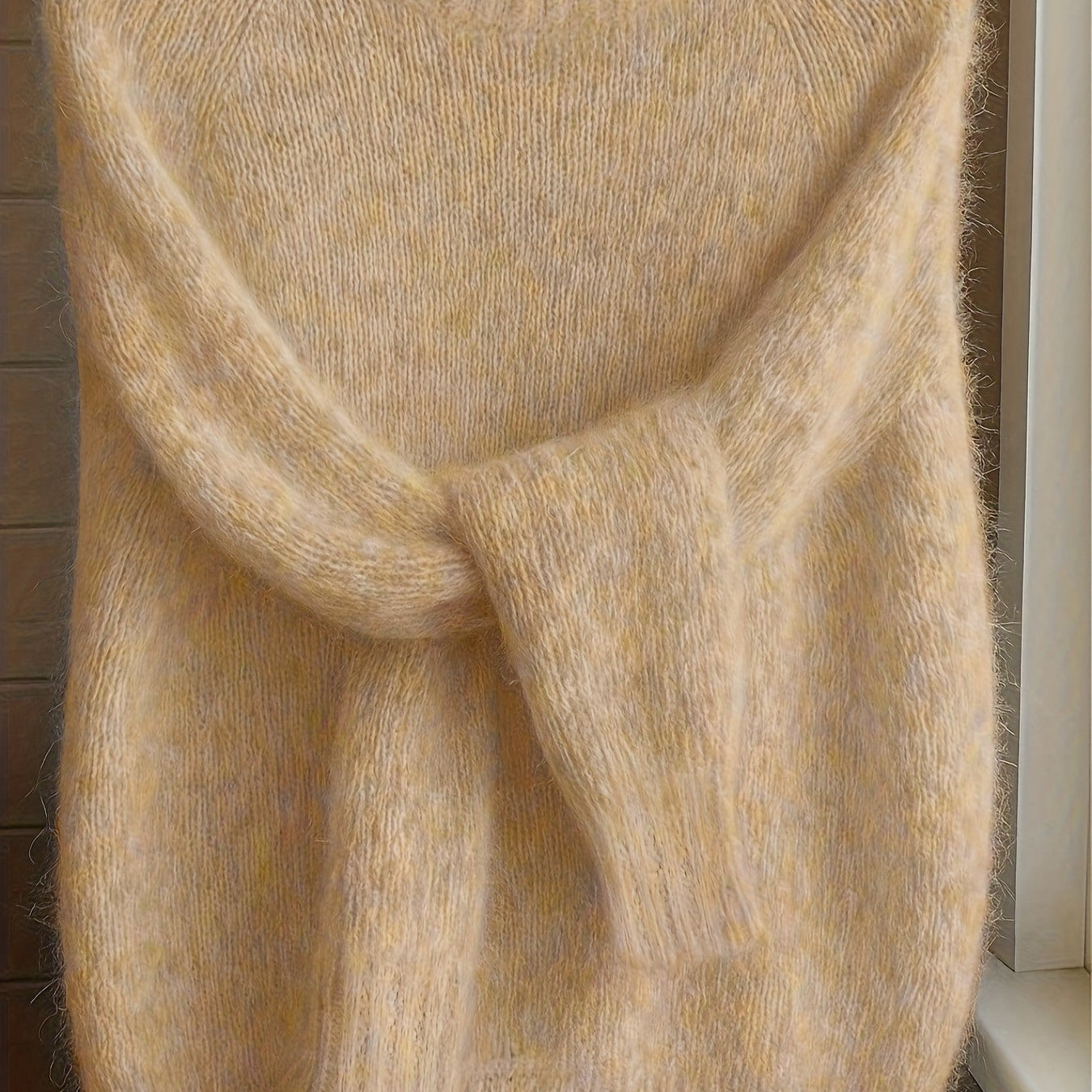 Front view of the Elara cashmere-blend sweater in a soft apricot color, showcasing its relaxed fit.