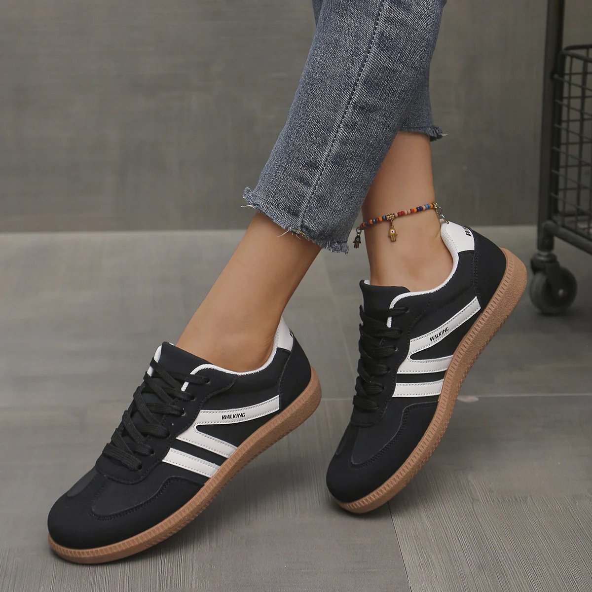 Close-up on the intricate stitching and material texture of the black Elara orthopaedic cushioned trainers.