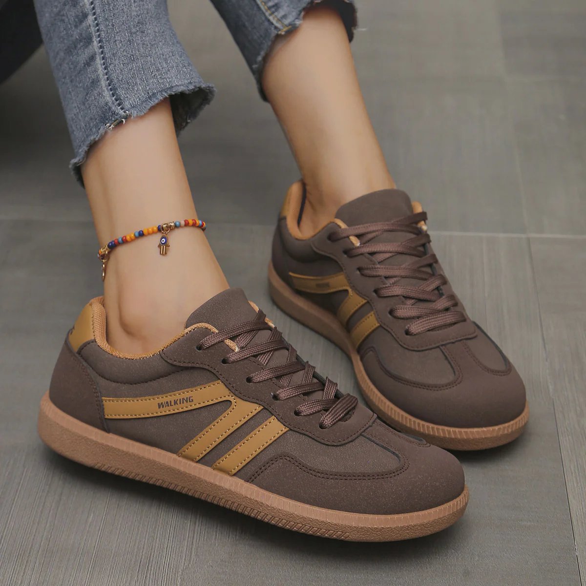 A woman's feet in leopard print Elara orthopaedic cushioned trainers, styled with casual jeans.