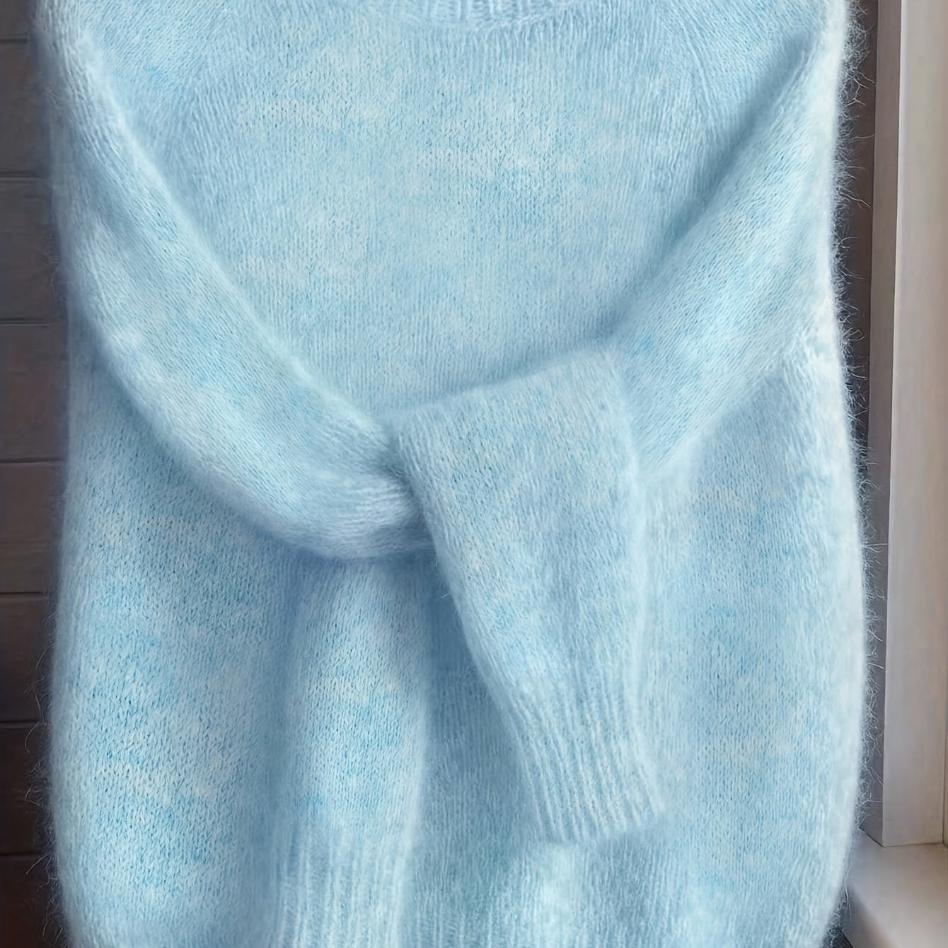 Detail shot of the cuff and sleeve of the Elara cashmere-blend sweater in blue, emphasizing the soft material.