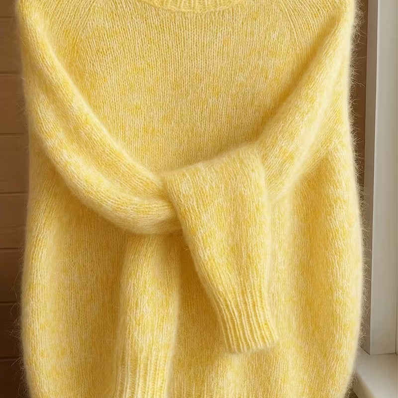 Lifestyle image of a woman comfortably wearing the Elara cashmere-blend sweater while reading a book indoors.