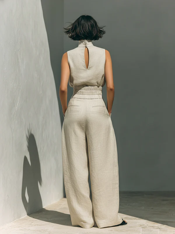 Model wearing beige wide-leg trousers, demonstrating a comfortable and elegant fit from a standing pose.