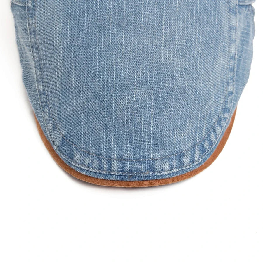 Man adjusting the Kian classic denim flat cap, capturing its ease of wear and versatile appeal.
