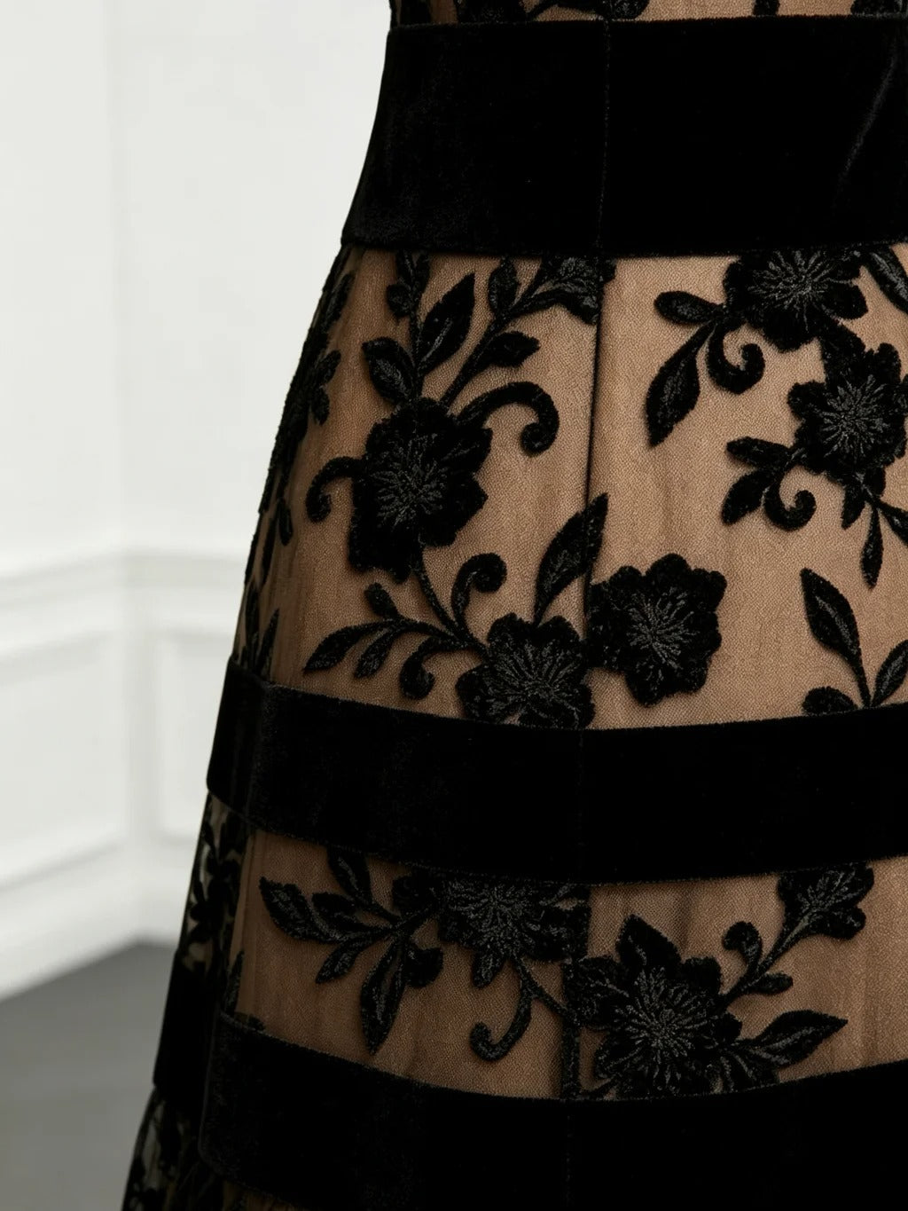 Woman wearing the stunning embroidered tulle midi dress at an evening event, paired with elegant accessories.