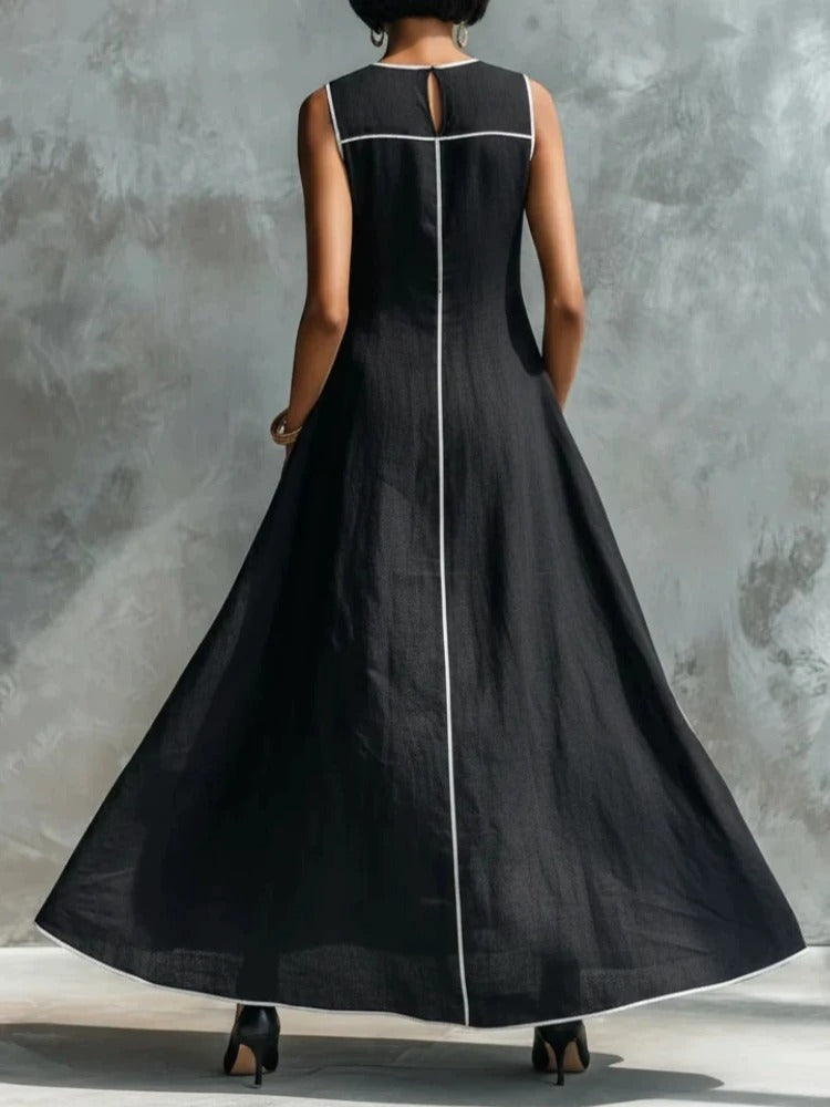 Model wearing a flowing burgundy maxi dress, showcasing the wide skirt and side pockets in a relaxed pose.