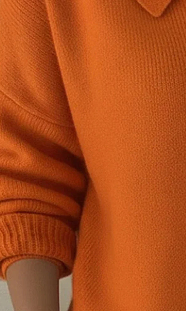 Marlow everyday cardigan in a bright orange, showcasing the smooth knit and simple sleeve finishes.
