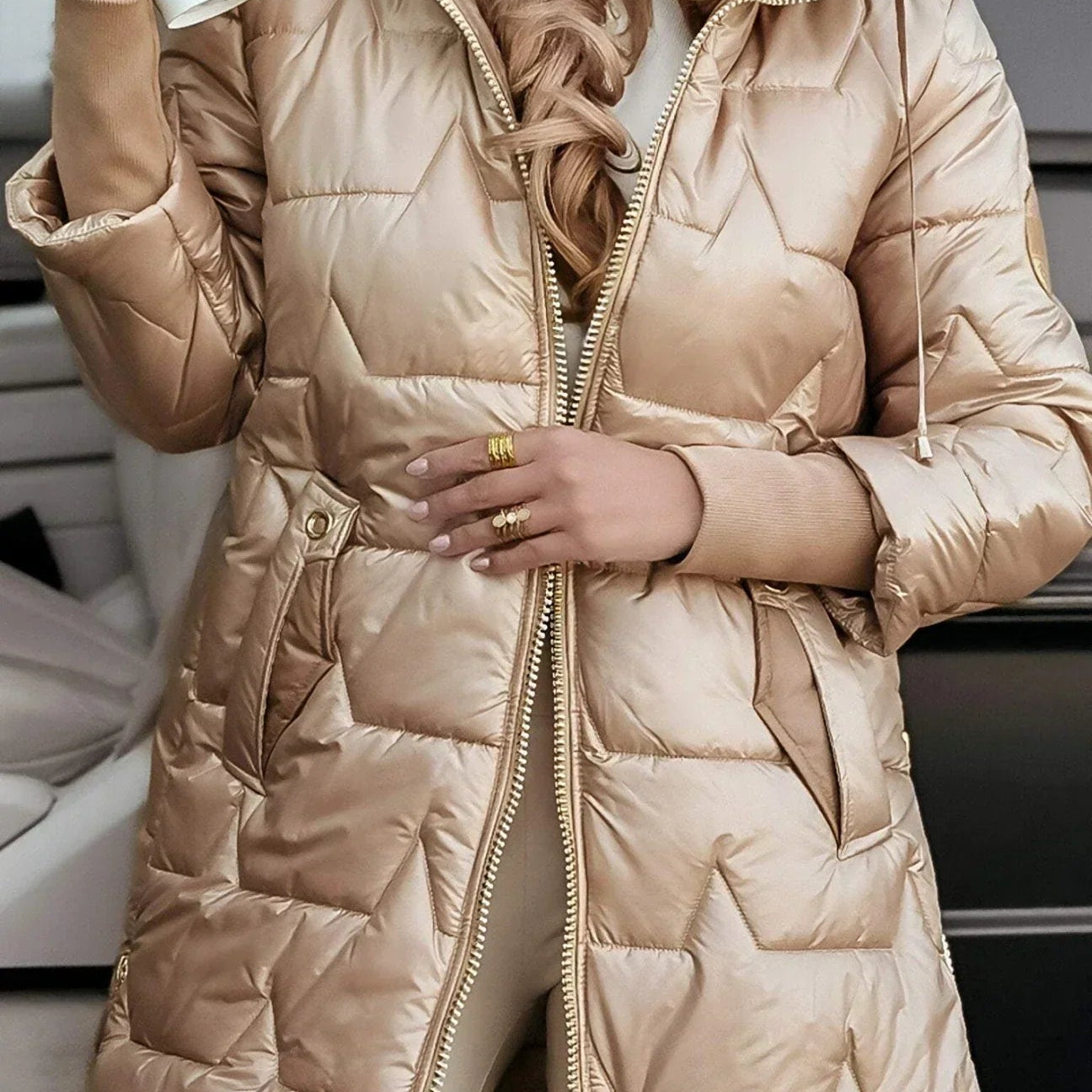 Detail shot of the hood on a pink hooded winter jacket, focusing on its protective design.