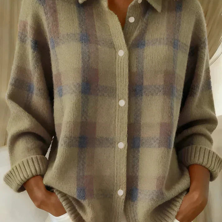 Woman comfortably seated, wearing the orange Sable relaxed fit cardigan, illustrating its comfort.