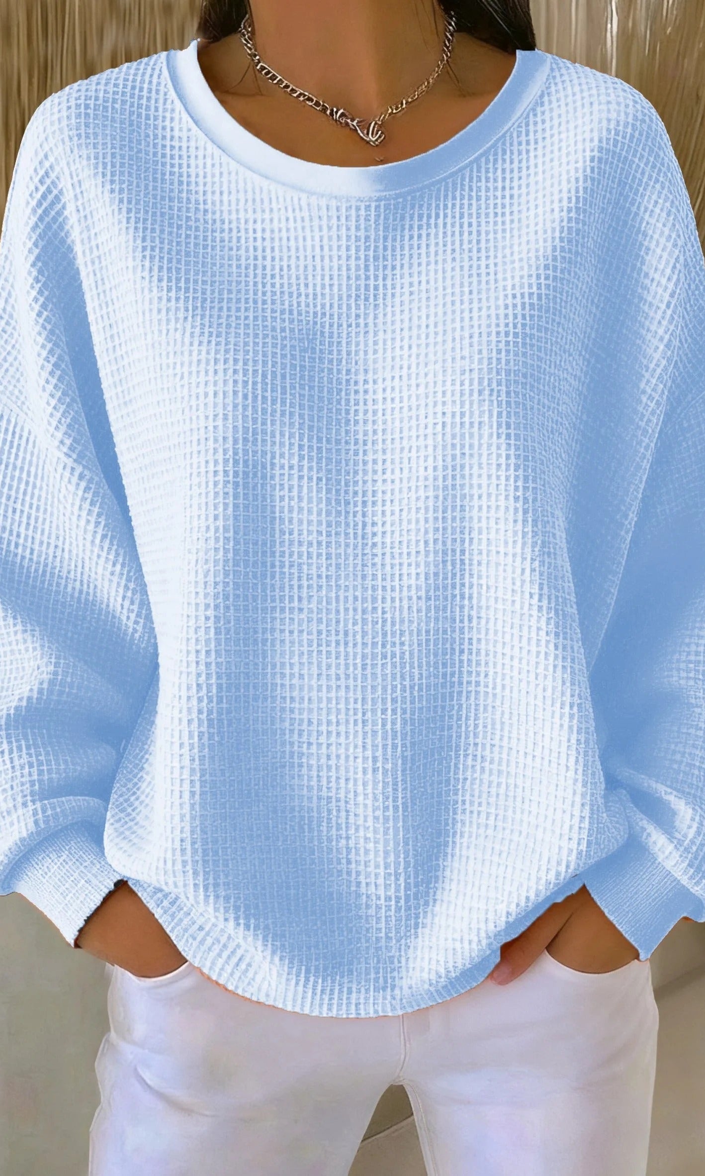 Front view of a woman wearing the Soraya knitted wide collar sweater in a light color, showcasing its loose fit.