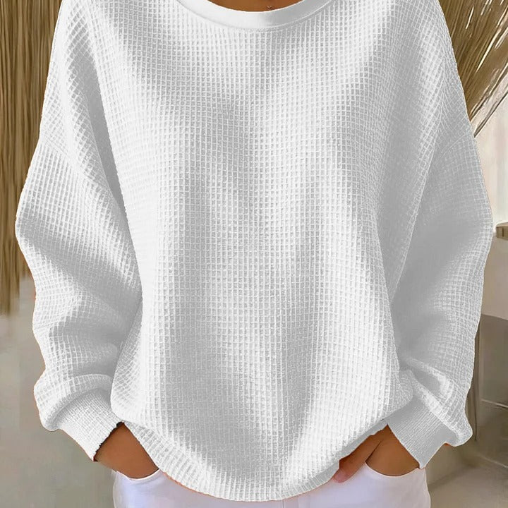 Model in a studio setting, posing in a vibrant colored Soraya knitted wide collar sweater, full length shot.