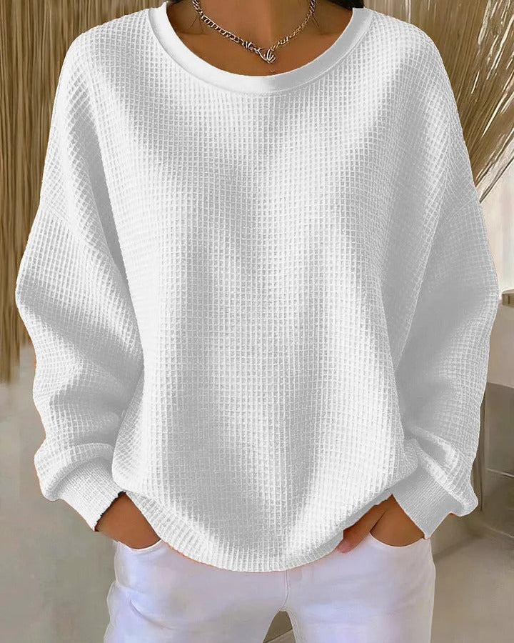 Model in a studio setting, posing in a vibrant colored Soraya knitted wide collar sweater, full length shot.