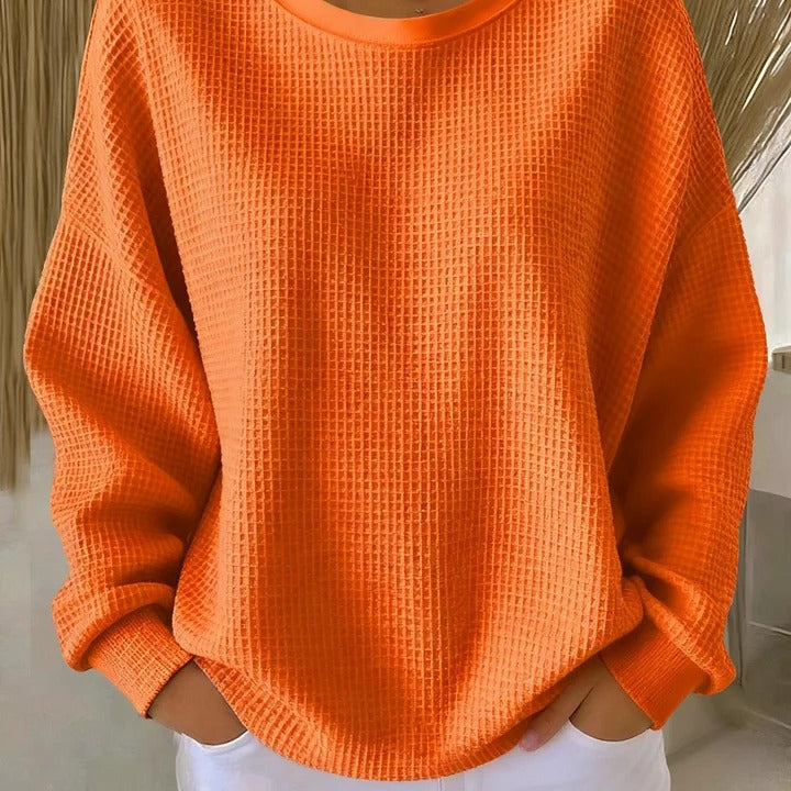 Woman walking outdoors, styled casually in the Soraya knitted wide collar sweater, in a practical context.