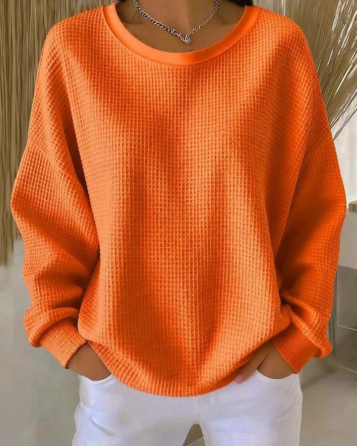 Woman walking outdoors, styled casually in the Soraya knitted wide collar sweater, in a practical context.