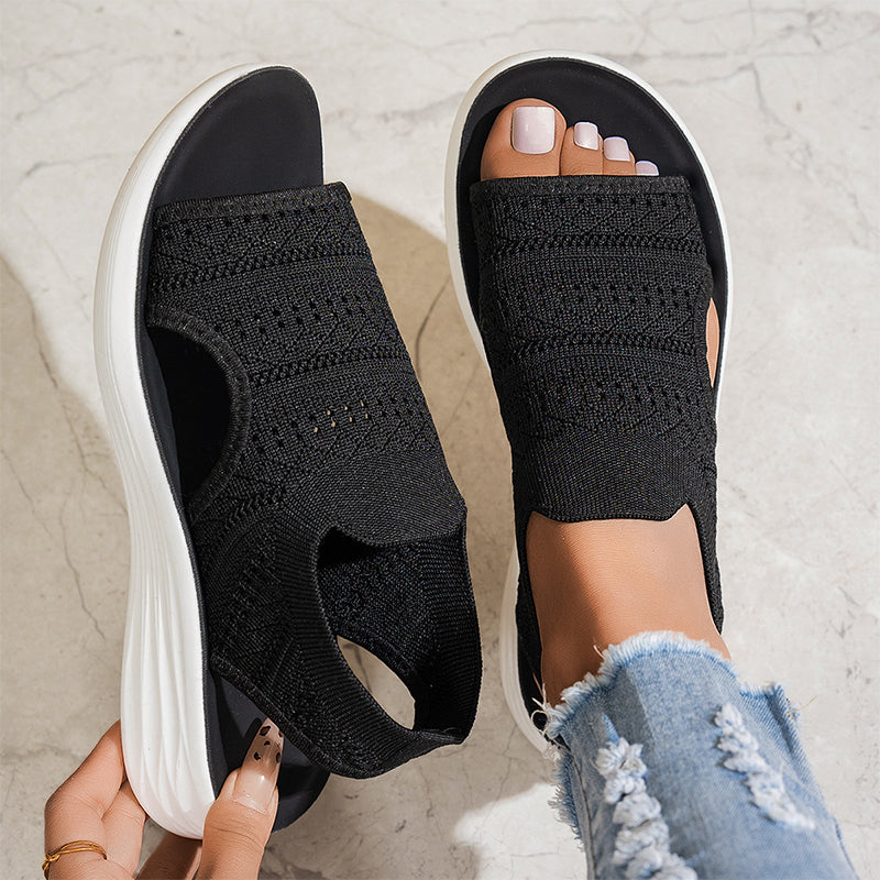 Side profile of black comfortable platform sandals, highlighting the supportive design and flexible construction.