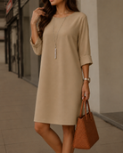 Back view of the vibrant orange-red midi dress, emphasizing its clean lines and comfortable, relaxed design.