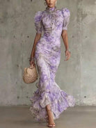 Lifestyle shot of a woman enjoying an outdoor garden event while wearing the charming floral maxi dress.