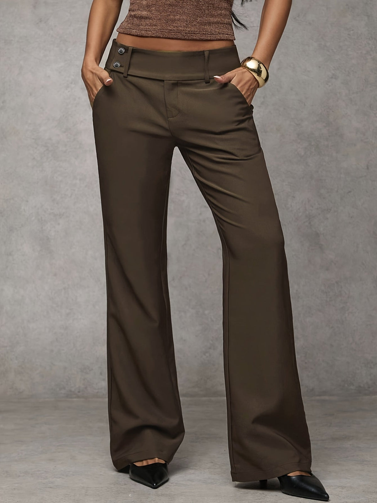 A pair of dark grey Indira trousers neatly folded, showing the refined finish and versatile color option.