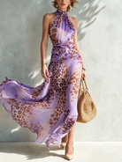 Close-up of the twisted waist detail and the beginning of the flowing skirt on a refined animal print maxi dress.