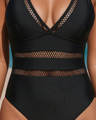Close-up detail of the fabric texture on the navy one-piece, illustrating its quality and smooth feel.