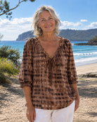 Brown linen-look polyester blouse, detailed view of the elegant ruffled V-neck tie.