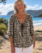 Black boho print blouse, photographed from the side, demonstrating its flowing drape and relaxed charm.