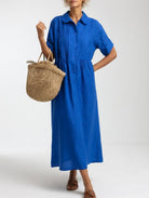 Close-up of the light blue cotton shirt dress fabric, showcasing the breathable texture and quality material.