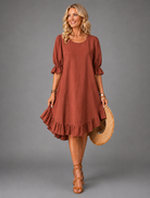 Side profile of the Nora midi dress in green, highlighting its relaxed silhouette and drape.