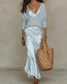 Texture shot of the ribbed knit sweater in a neutral tone, focusing on the material's softness.