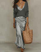 A woman layering a blue ribbed knit sweater over a dress for an elegant, multi-seasonal look.