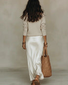 Side profile of the cream ribbed knit sweater, showing its relaxed fit and comfortable drape.