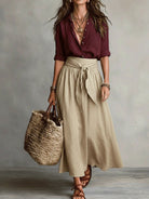 Lifestyle shot of the elegant midi skirt paired with a simple top, perfect for a casual daytime look.