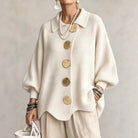 Side profile of the cream oversized sweater, showcasing its relaxed fit and curved hem.