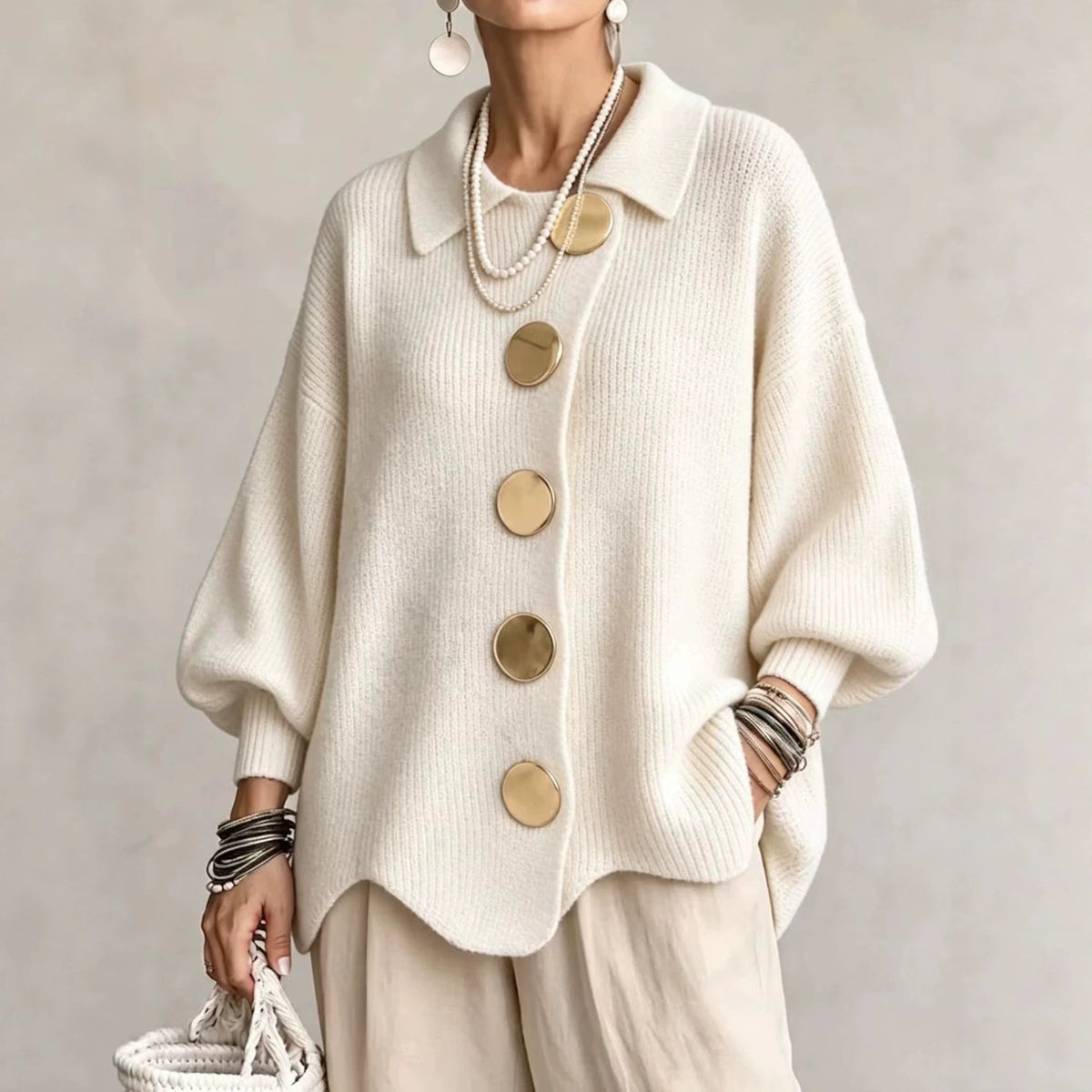 Side profile of the cream oversized sweater, showcasing its relaxed fit and curved hem.