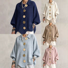 Close-up detail of the large sculptural metal buttons on the collared sweater.
