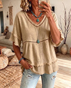 Model wearing a khaki frill trim blouse, styled casually with a pair of jeans for a laid-back look.