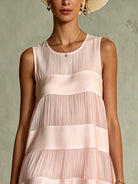 Full front view of the light pink layered mini dress, showcasing its flattering A-line cut and gathered ruffled hem.