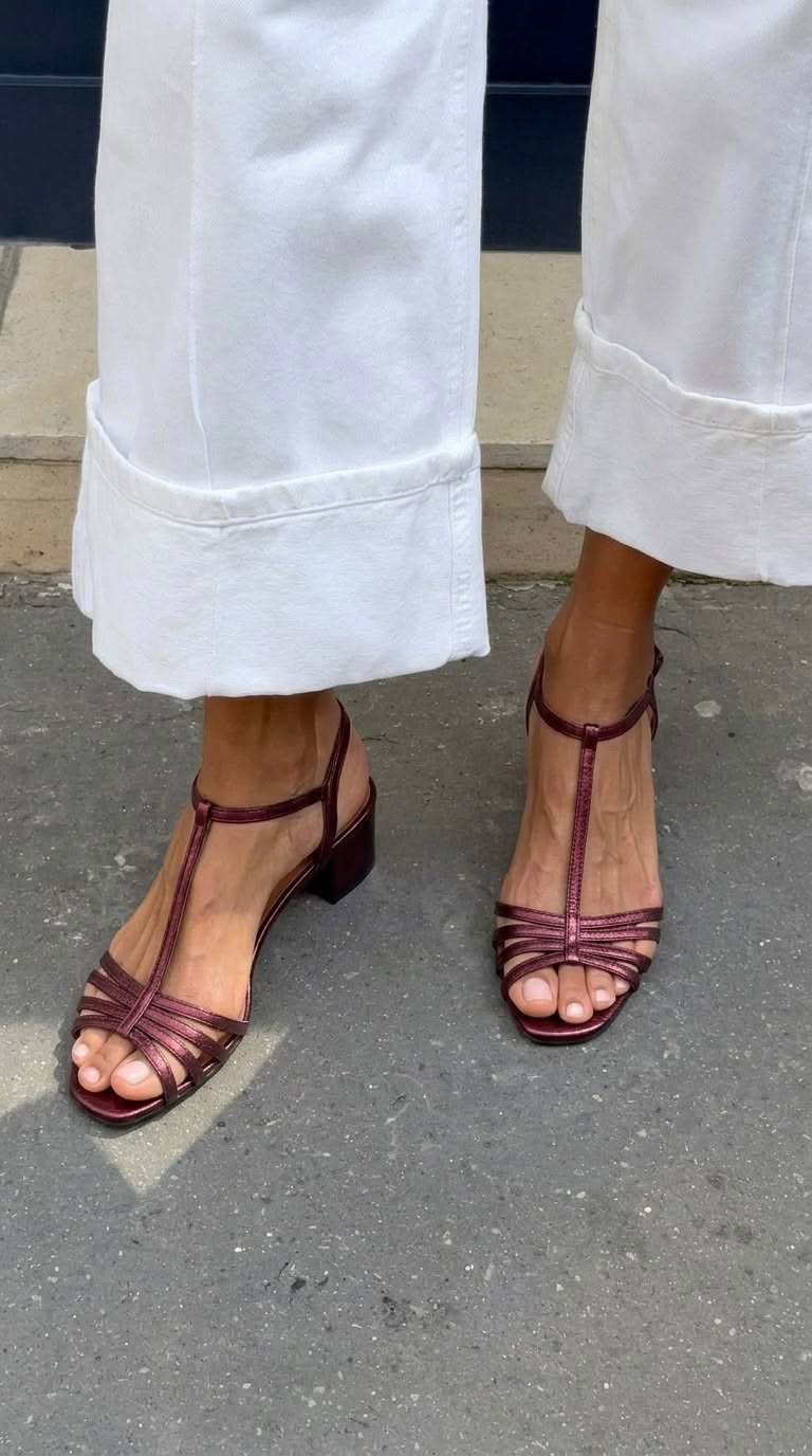 Woman's feet wearing Allegra vintage sandals, relaxing in a garden setting.