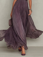 Lifestyle shot of the purple chiffon lace maxi dress in a garden setting, emphasizing its suitability for outdoor events.