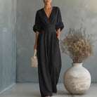 Side profile of a white V-neck jumpsuit, showcasing the wide-leg design and effortless comfort.