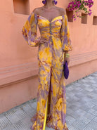 Close-up detail of the warm-toned floral print on the lightweight fabric of the elegant maxi dress.