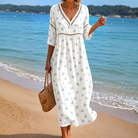 A model wearing the Camille flowing summer midi dress with small blue floral print, showcasing its relaxed fit and elegant drape.